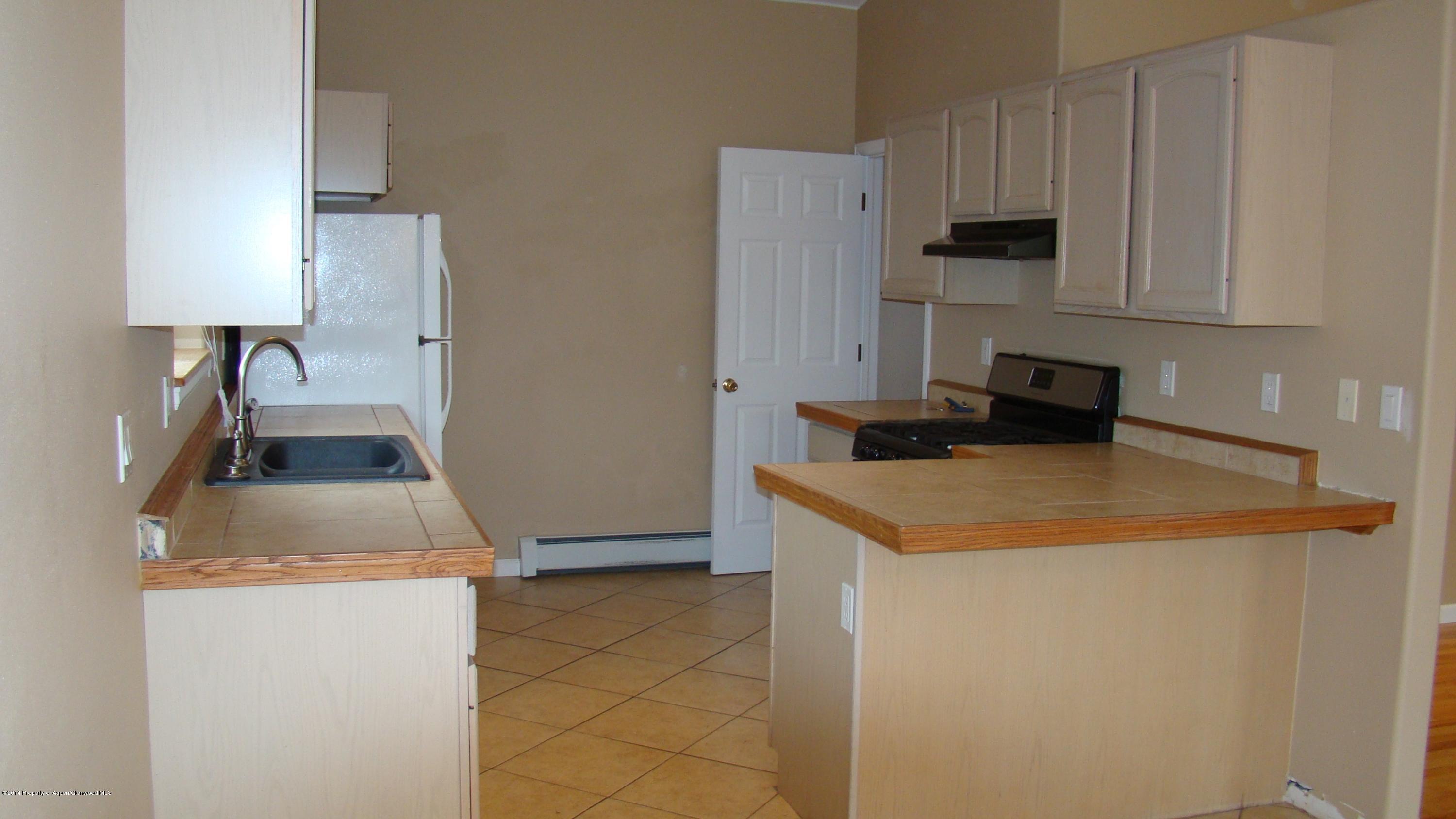 1462 Graham Court Rifle, CO 81650 - Photo 8 of 18 a kitchen with a sink a stove and a refrigerator