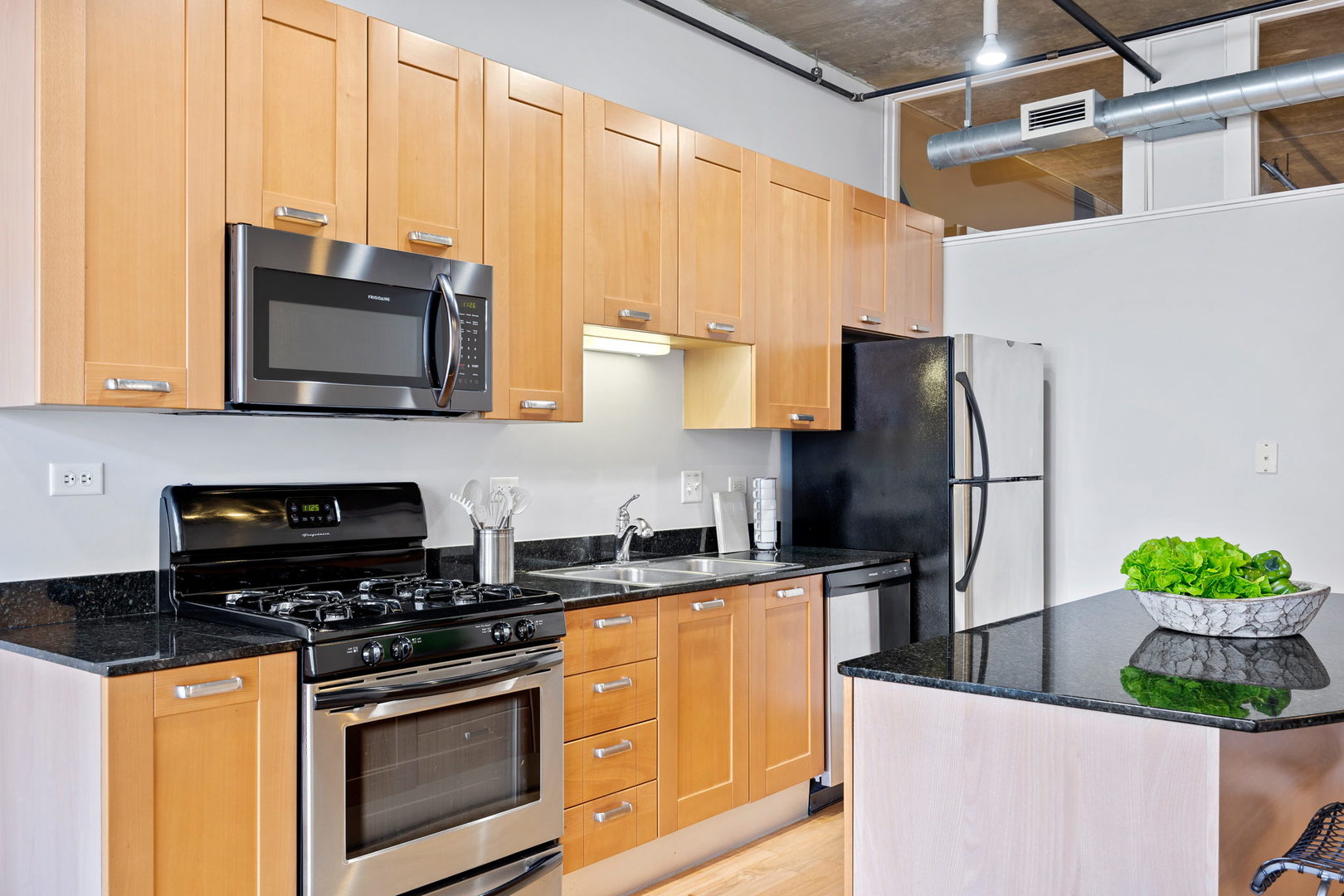111 South Morgan Street, Unit 707 Chicago, IL 60607 - Photo 8 of 22 a kitchen with stainless steel appliances granite countertop a stove a refrigerator and a microwave