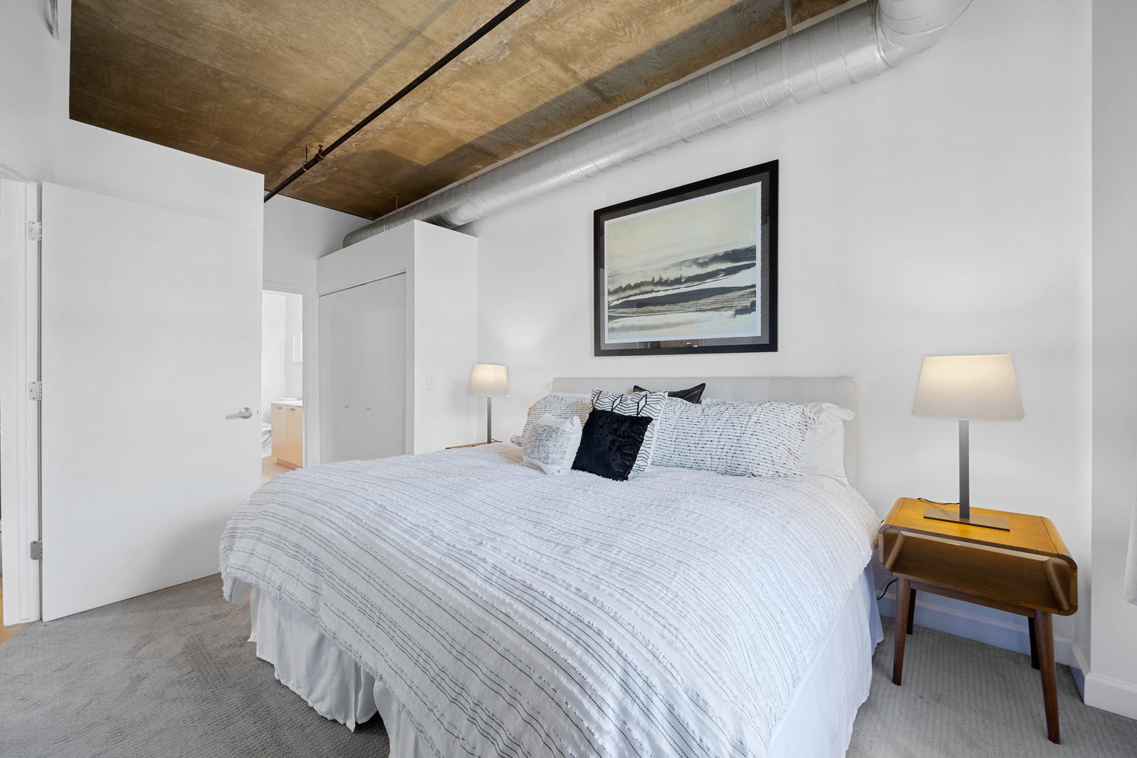 111 South Morgan Street, Unit 707 Chicago, IL 60607 - Photo 10 of 22 a bedroom with a bed and a lamp