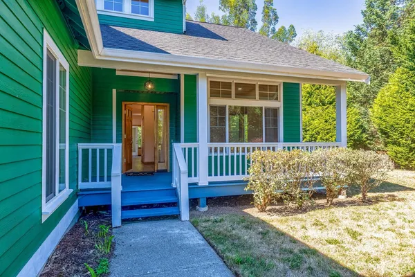 a view of a house with a small yard and wooden fence