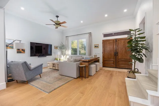 a living room with furniture a flat screen tv and a chandelier