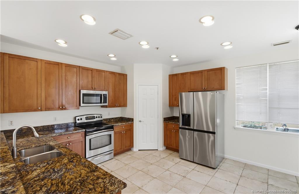 103 Cat Rock Lane Jupiter, FL 33458 - Photo 15 of 32 a kitchen with stainless steel appliances granite countertop a refrigerator and a stove top oven