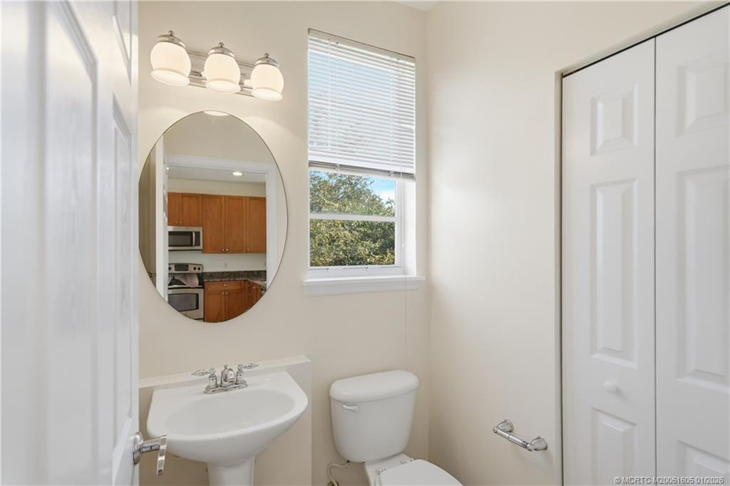 103 Cat Rock Lane Jupiter, FL 33458 - Photo 21 of 32 a bathroom with a toilet sink and mirror