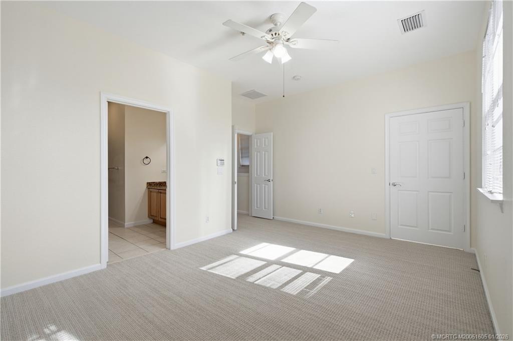 103 Cat Rock Lane Jupiter, FL 33458 - Photo 27 of 32 an empty room with chandelier fan and windows