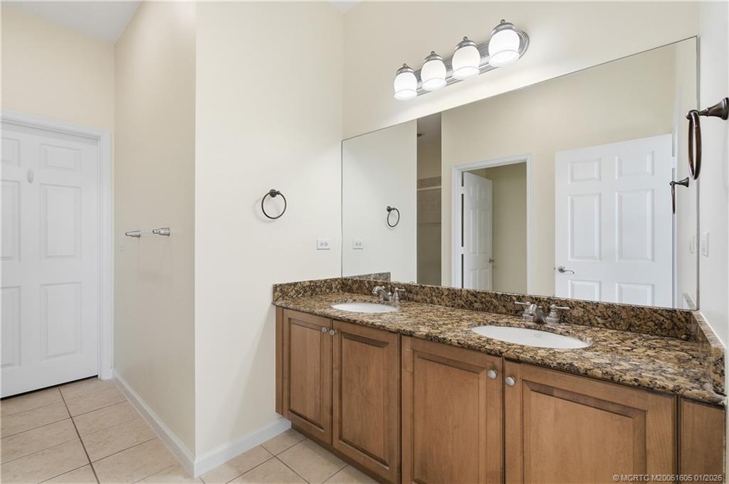 103 Cat Rock Lane Jupiter, FL 33458 - Photo 28 of 32 a bathroom with a granite countertop sink and a mirror