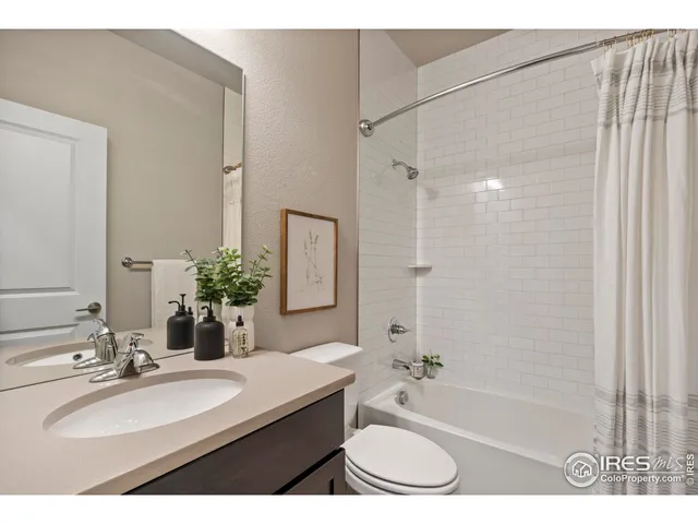 a bathroom with a granite countertop sink a mirror a bathtub and shower