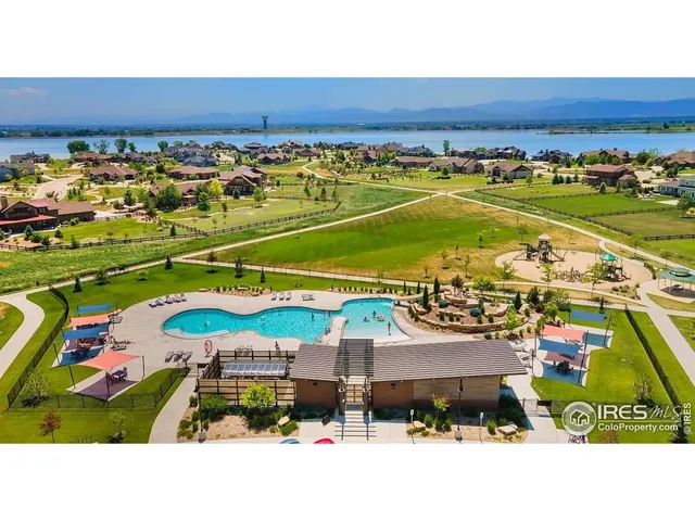 a view of a swimming pool with a lawn chairs under an umbrella