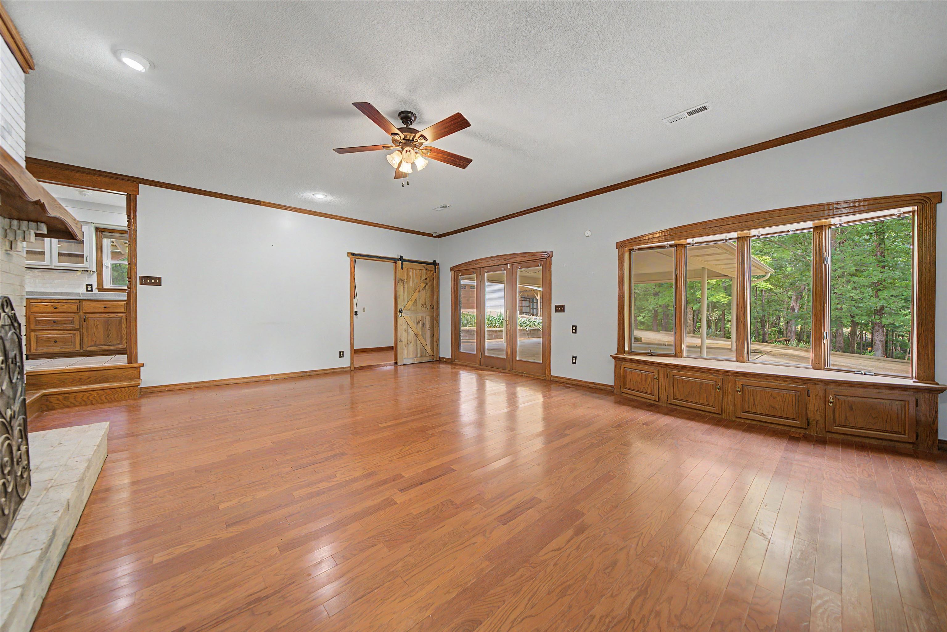436 Skyline Road Selmer, TN 38375 - Photo 31 of 40 Spacious interior featuring wood-finish flooring, a decorative fireplace, and a bay window with integrated cabinetry