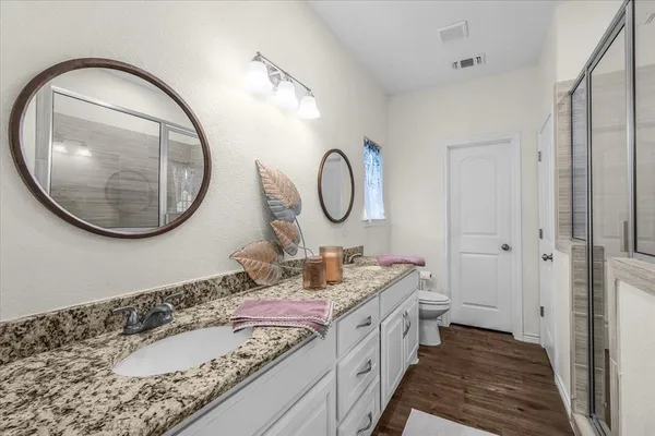 a bathroom with a glass shower door and a sink