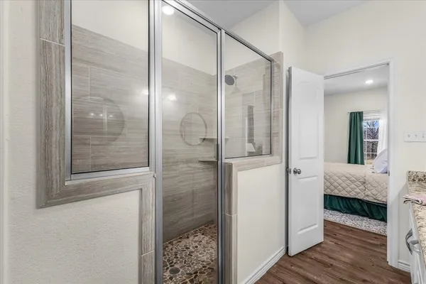 a en suite bathroom with a granite countertop tub and a mirror