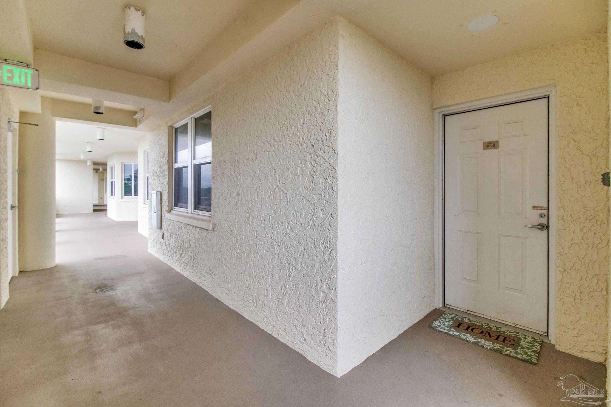 612 Lost Key Drive, Unit 405B Pensacola, FL 32507 - Photo 18 of 71 a view of a hallway with wooden floor and a living room