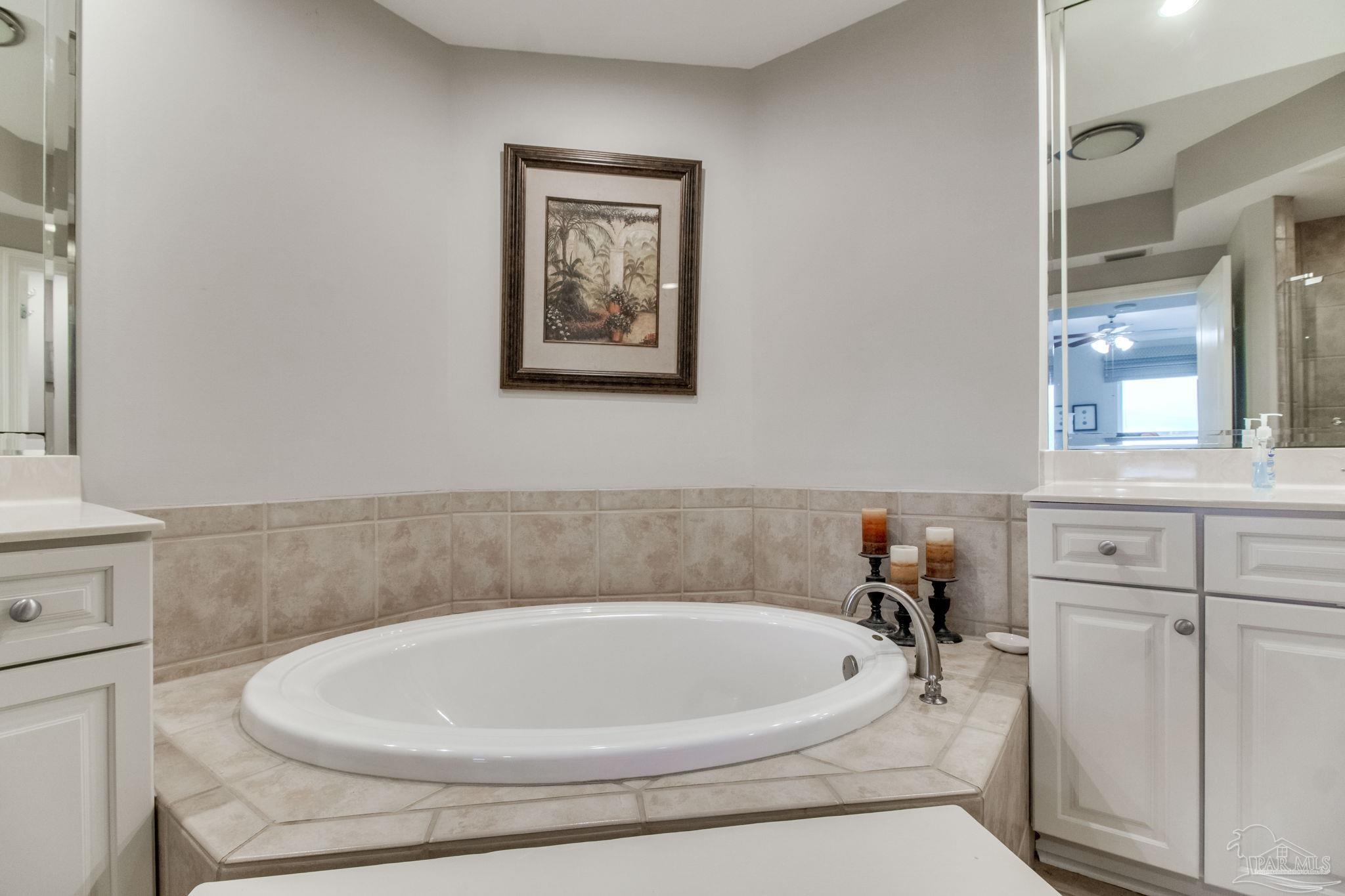 612 Lost Key Drive, Unit 405B Pensacola, FL 32507 - Photo 22 of 71 a bathroom with a white tub a sink and a window