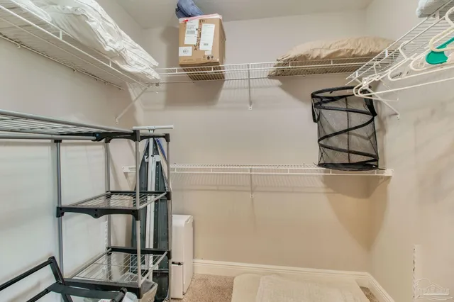 a bedroom with a bed and a lamp on dresser