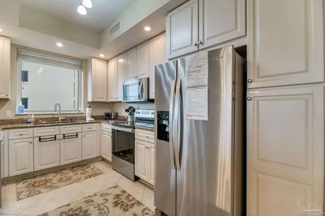a kitchen with stainless steel appliances kitchen island granite countertop a sink and cabinets