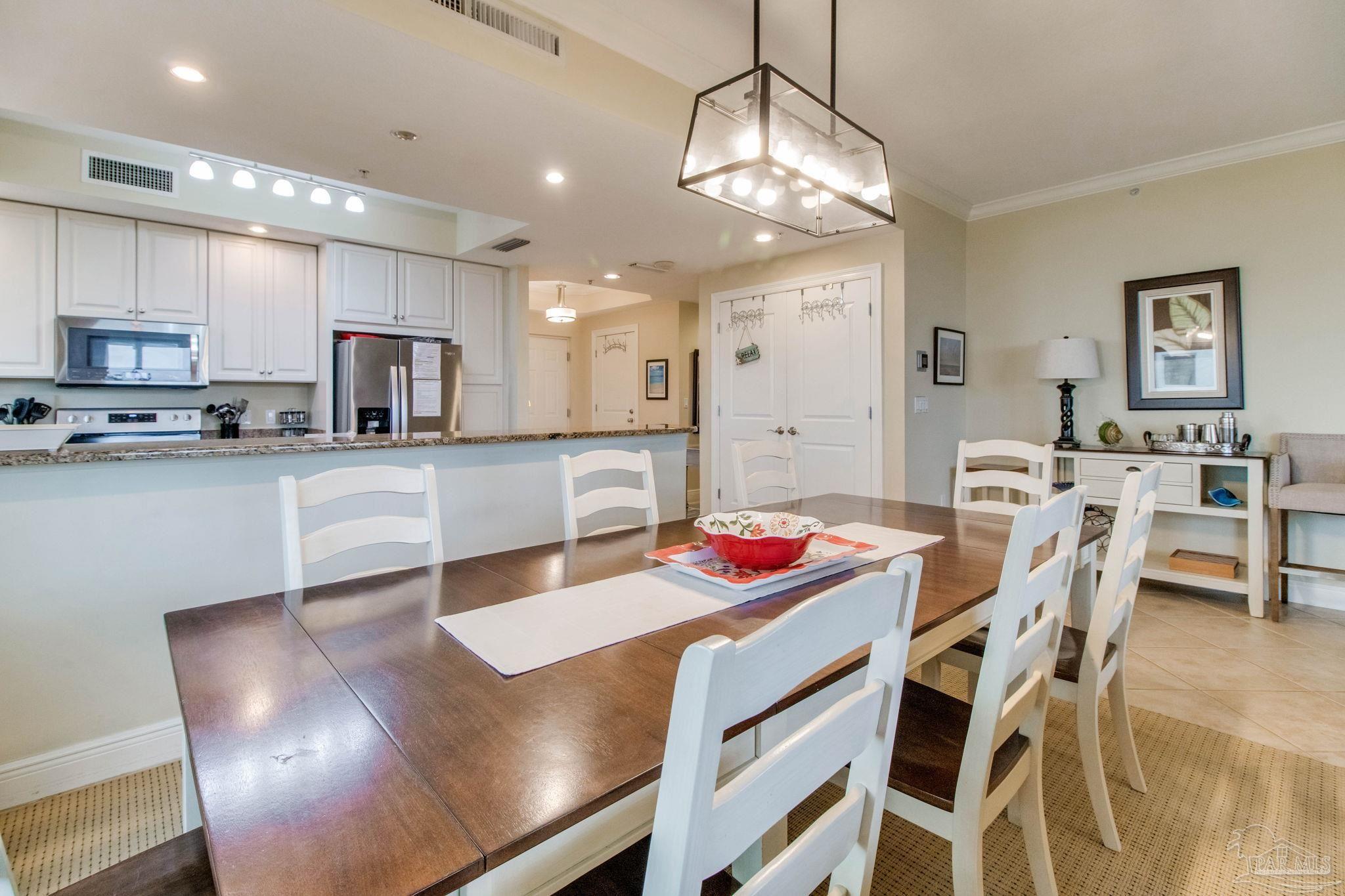 612 Lost Key Drive, Unit 405B Pensacola, FL 32507 - Photo 33 of 71 a kitchen with kitchen island a dining table chairs and white cabinets