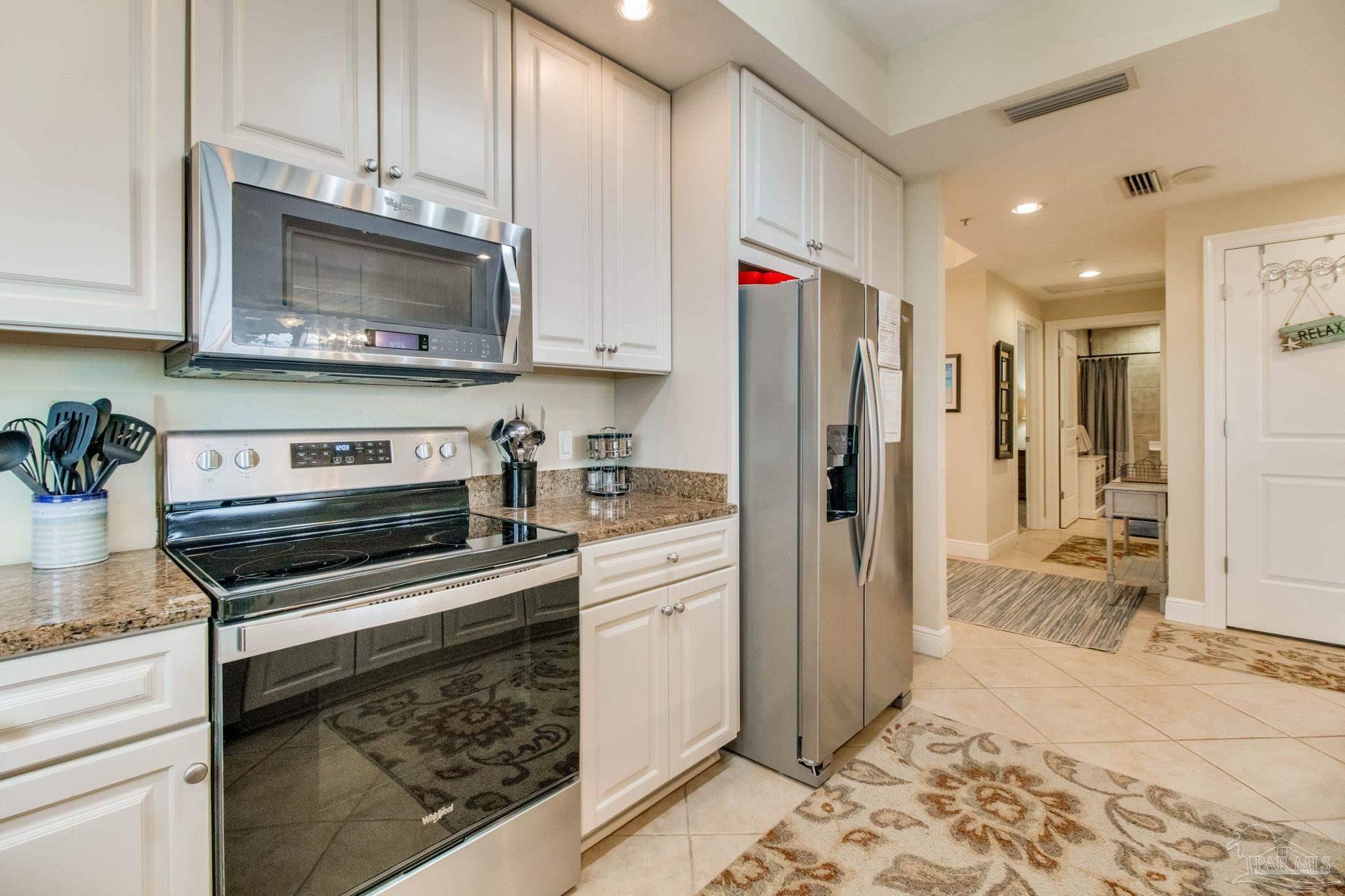 612 Lost Key Drive, Unit 405B Pensacola, FL 32507 - Photo 36 of 71 a kitchen with stainless steel appliances granite countertop a refrigerator and a stove top oven