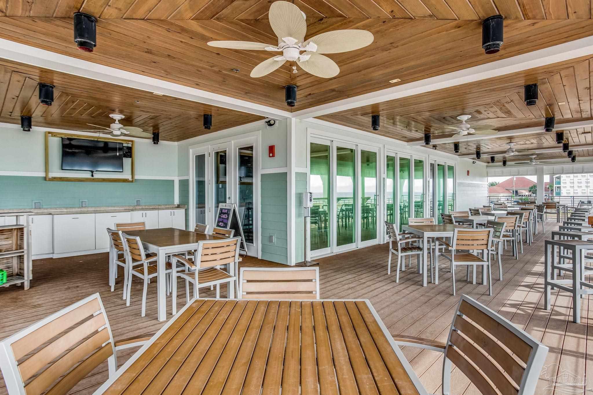 612 Lost Key Drive, Unit 405B Pensacola, FL 32507 - Photo 57 of 71 a dining room with wooden floor outdoor seating and stainless steel appliances