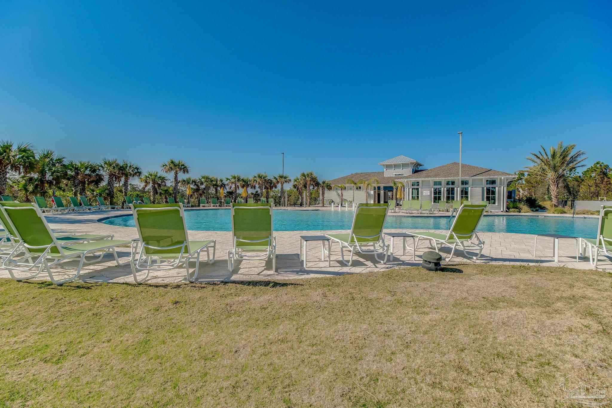 612 Lost Key Drive, Unit 405B Pensacola, FL 32507 - Photo 68 of 71 a view of a chair with table and chairs under an umbrella