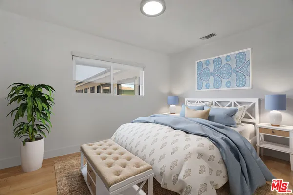 a bedroom with bed and a potted plant