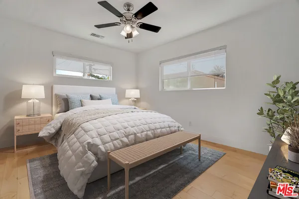 a bedroom with a bed chandelier and a window