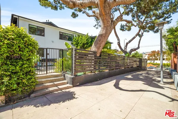 a view of a pathway of a house with wooden fence