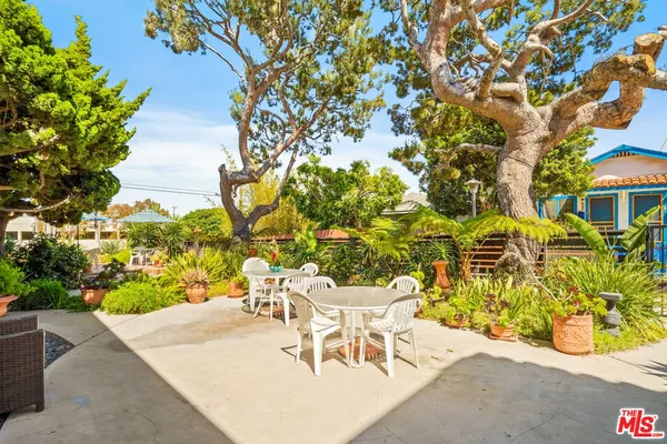 a view of a patio with table and chairs and potted plants