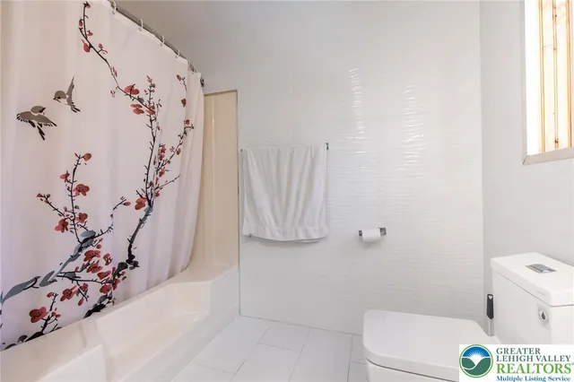 a bathroom with a toilet and shower curtain
