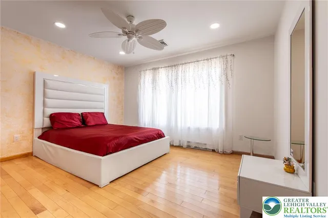 a spacious bedroom with a bed and a chandelier