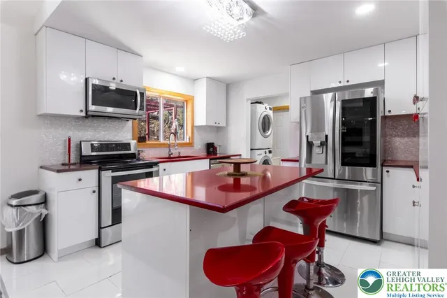 a kitchen with stainless steel appliances granite countertop a sink and a refrigerator