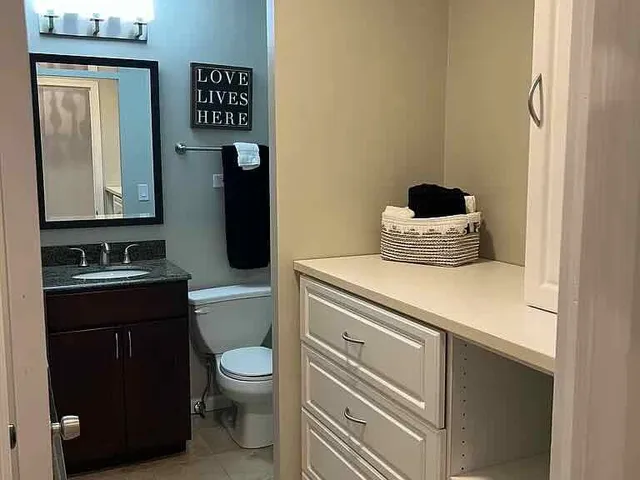 a bathroom with a toilet sink and mirror