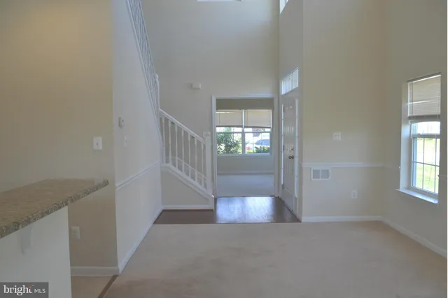 a view of a hallway with wooden floor and a living room