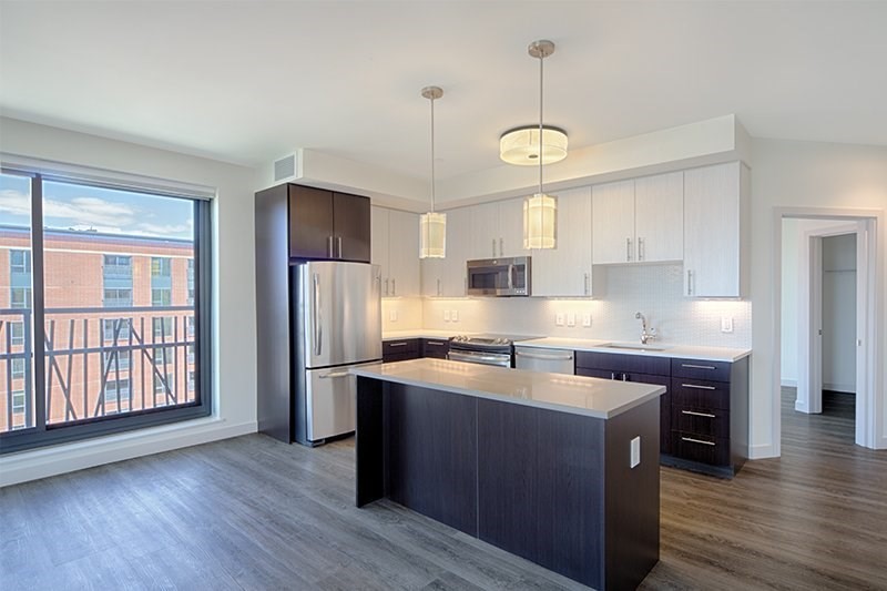 1 Canal Street, Unit 804 Boston, MA 02114 - Photo 1 of 12 a kitchen with stainless steel appliances granite countertop a stove a refrigerator a sink a center island and wooden floor