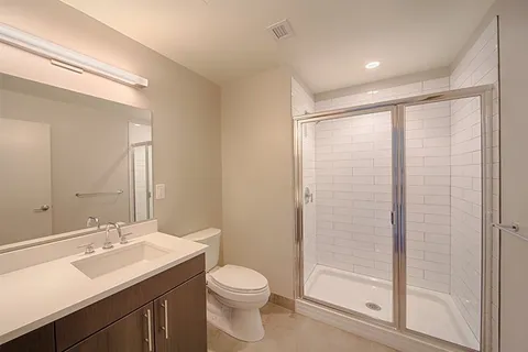 a bathroom with a sink a toilet and shower