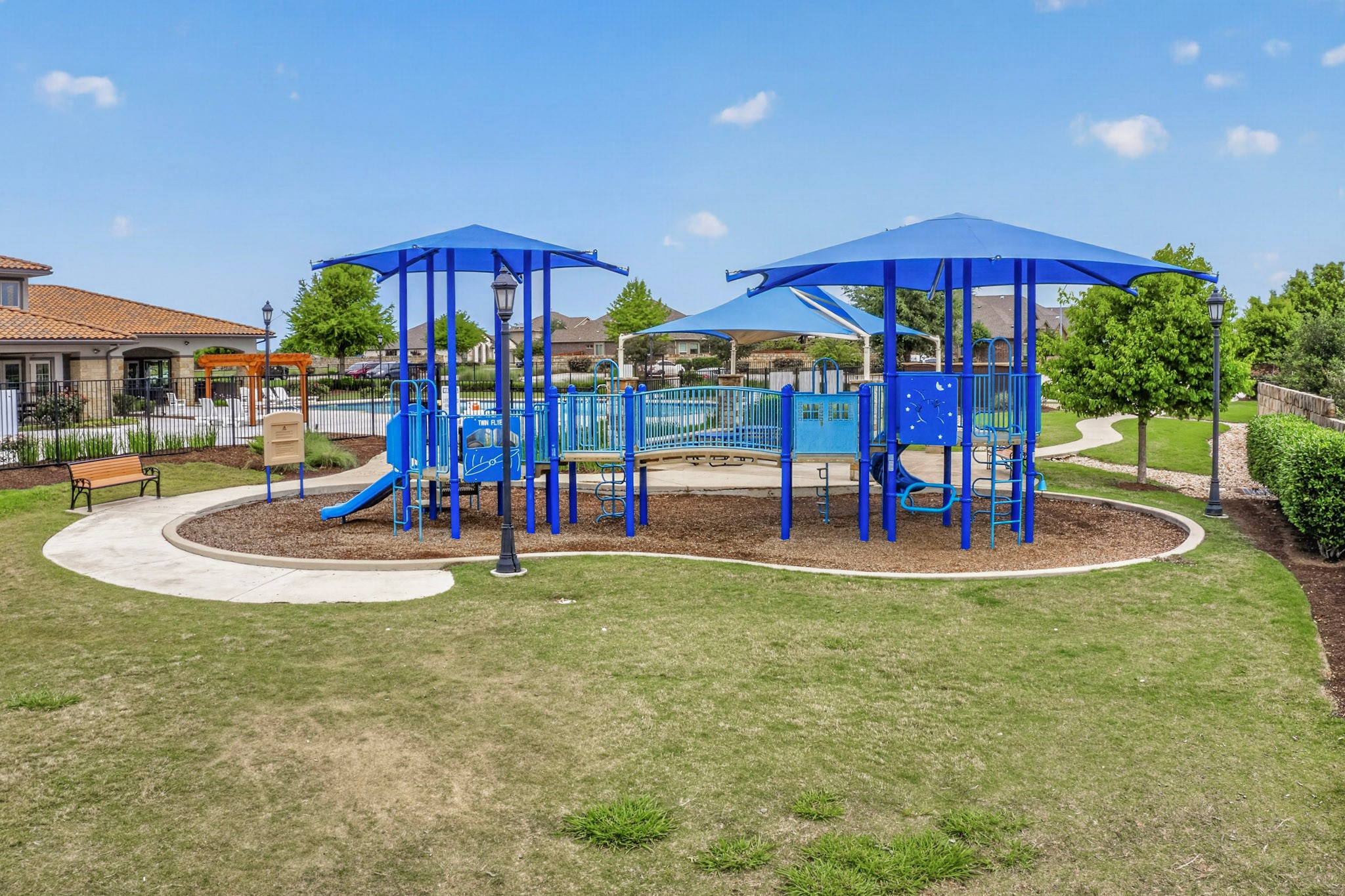 16809 Guido Cove Pflugerville, TX 78660 - Photo 40 of 40 Community playground featuring multiple play structures with shade canopies, surrounded by manicured turf and a paved walking path