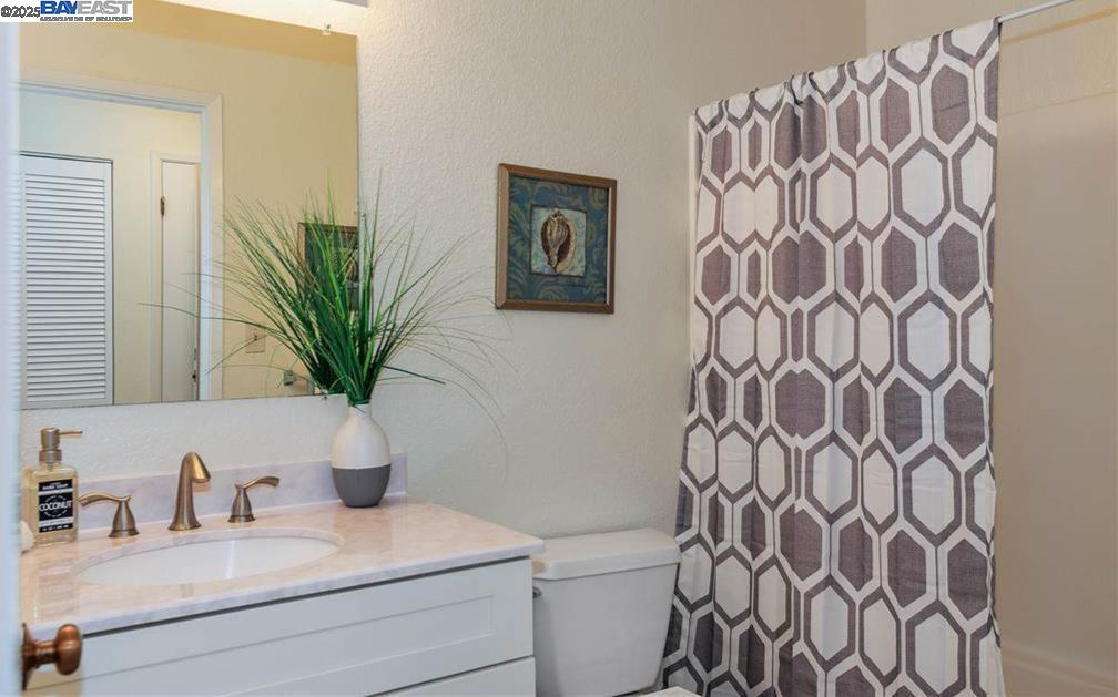 1310 Walden Road, Unit 11 Walnut Creek, CA 94597 - Photo 19 of 26 a bathroom with a sink a mirror and shower curtain