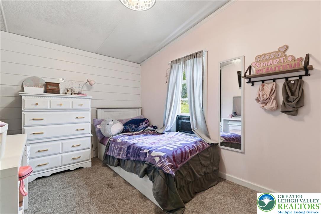 634 Main Road Lehighton, PA 18235 - Photo 29 of 39 A comforting bedroom features shiplap accent wall, soft carpet flooring, and ample natural light.