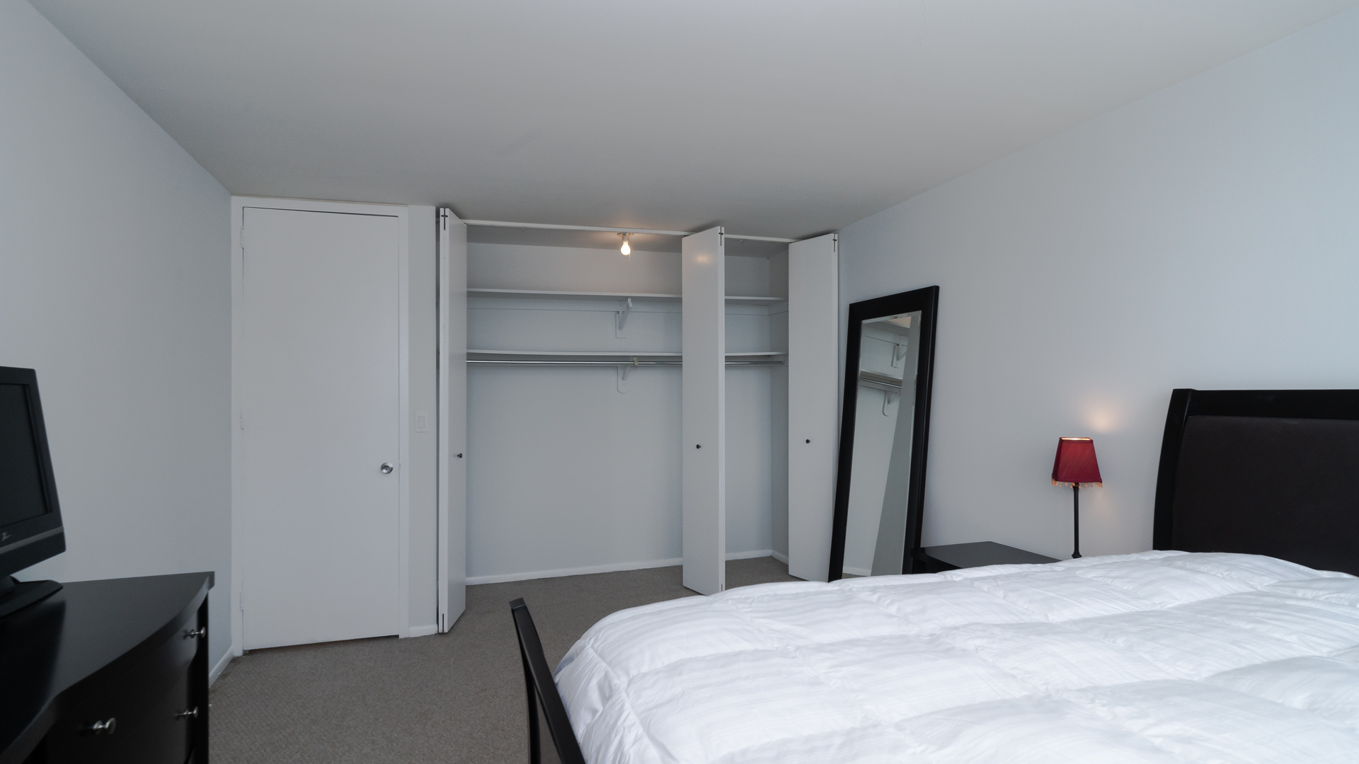 655 West Irving Park Road, Unit 803 Chicago, IL 60613 - Photo 11 of 25 a bedroom with a bed and a flat tv screen on a dresser