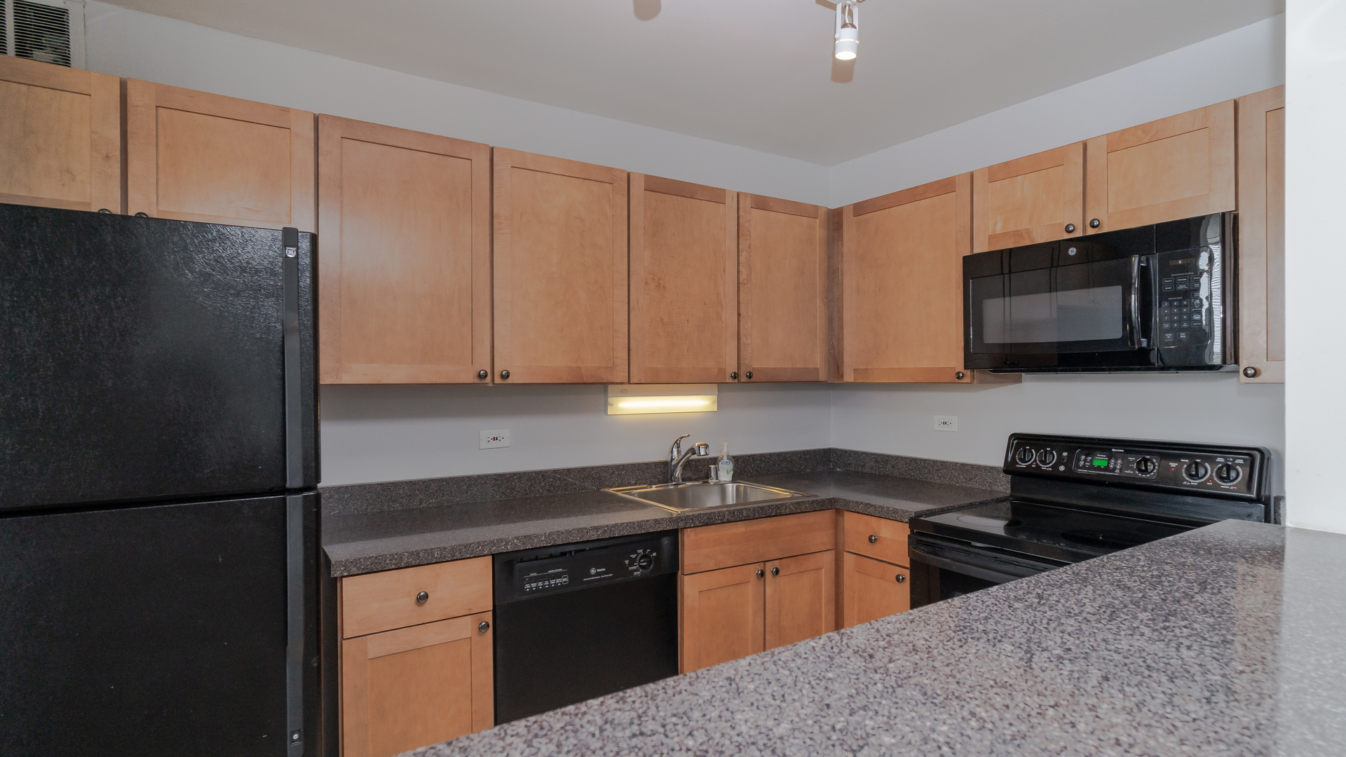 655 West Irving Park Road, Unit 803 Chicago, IL 60613 - Photo 8 of 25 a kitchen with stainless steel appliances granite countertop a refrigerator stove top oven and sink