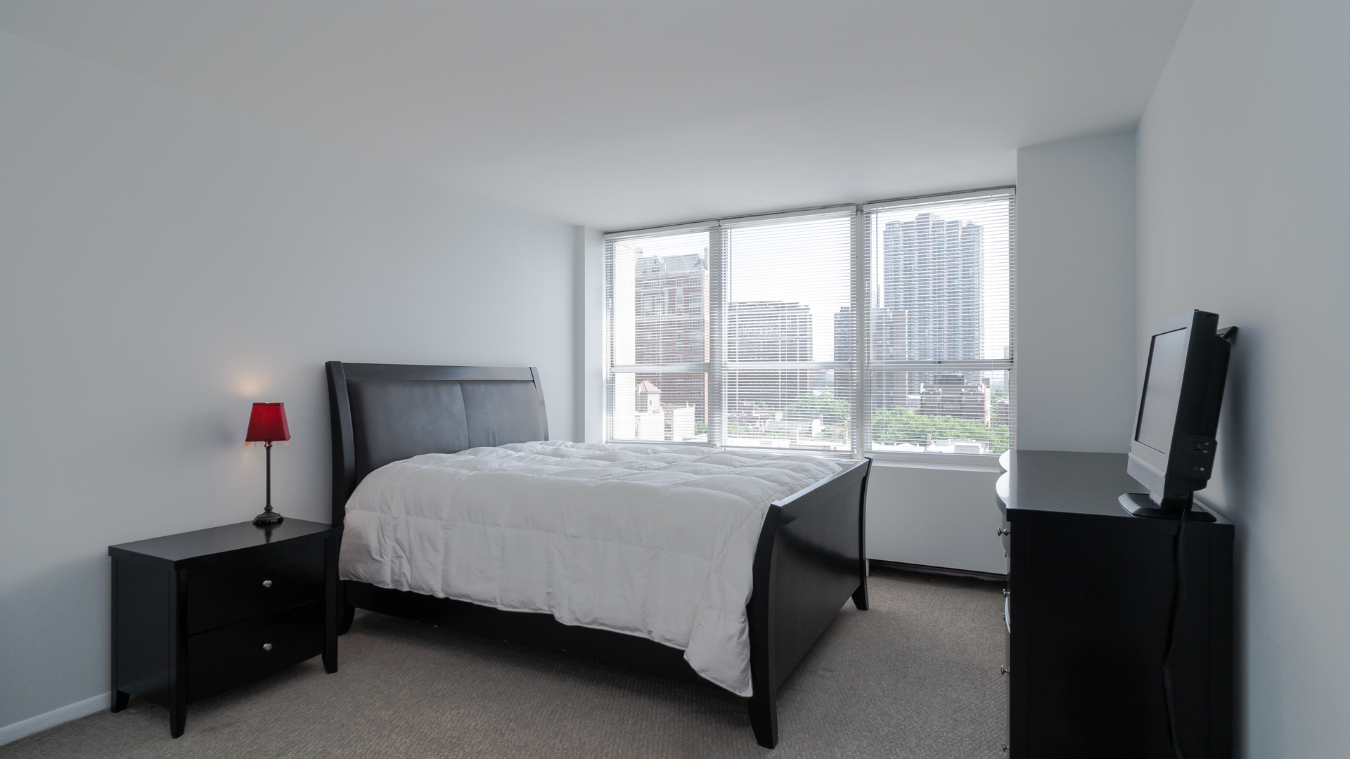 655 West Irving Park Road, Unit 803 Chicago, IL 60613 - Photo 9 of 25 a bedroom with a bed dresser and a window