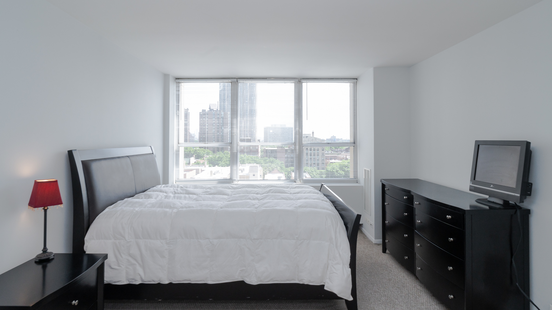655 West Irving Park Road, Unit 803 Chicago, IL 60613 - Photo 10 of 25 a bed sitting in a bedroom next to a window