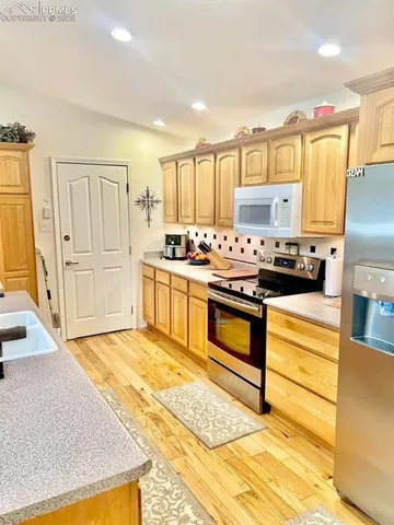 a kitchen with stainless steel appliances granite countertop a stove a sink dishwasher and a refrigerator