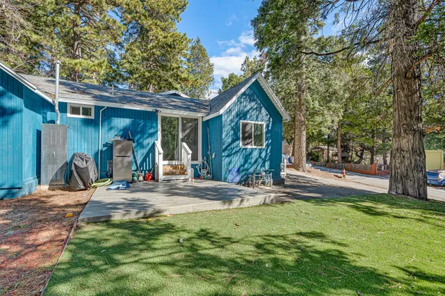 a view of a house with a small yard and wooden fence