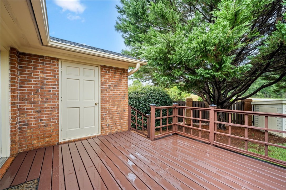 2004 Cardinal Park Drive Anderson, SC 29621 - Photo 37 of 40 An outdoor wooden deck adjoins classic brick walls under mature shade trees.