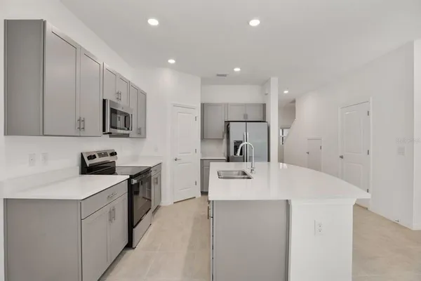 a kitchen with stainless steel appliances a sink stove and refrigerator