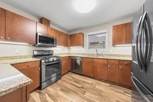 a kitchen with stainless steel appliances granite countertop a sink stove microwave and refrigerator