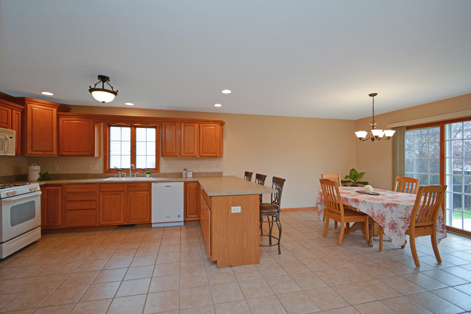 2884 Bear Claw Street Normal, IL 61761 - Photo 13 of 62 a kitchen with a dining table chairs and white appliances
