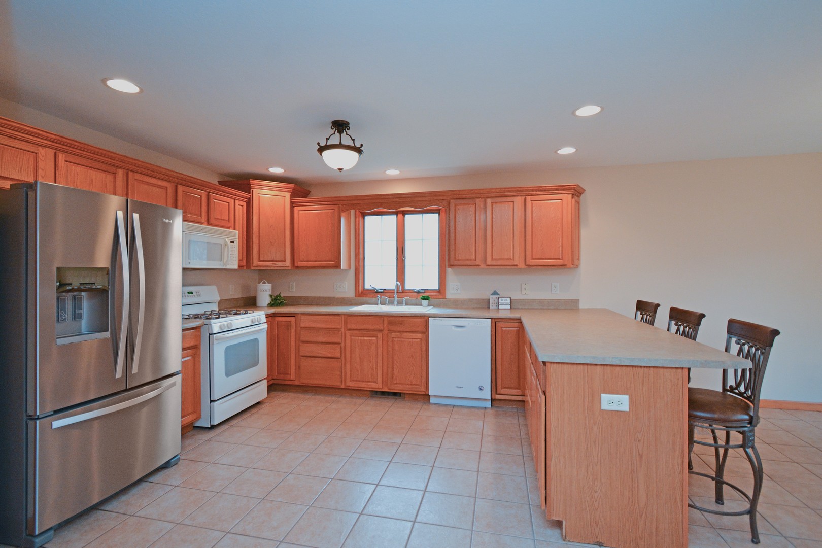 2884 Bear Claw Street Normal, IL 61761 - Photo 14 of 62 a kitchen with stainless steel appliances granite countertop a refrigerator a sink dishwasher a stove with chairs and island