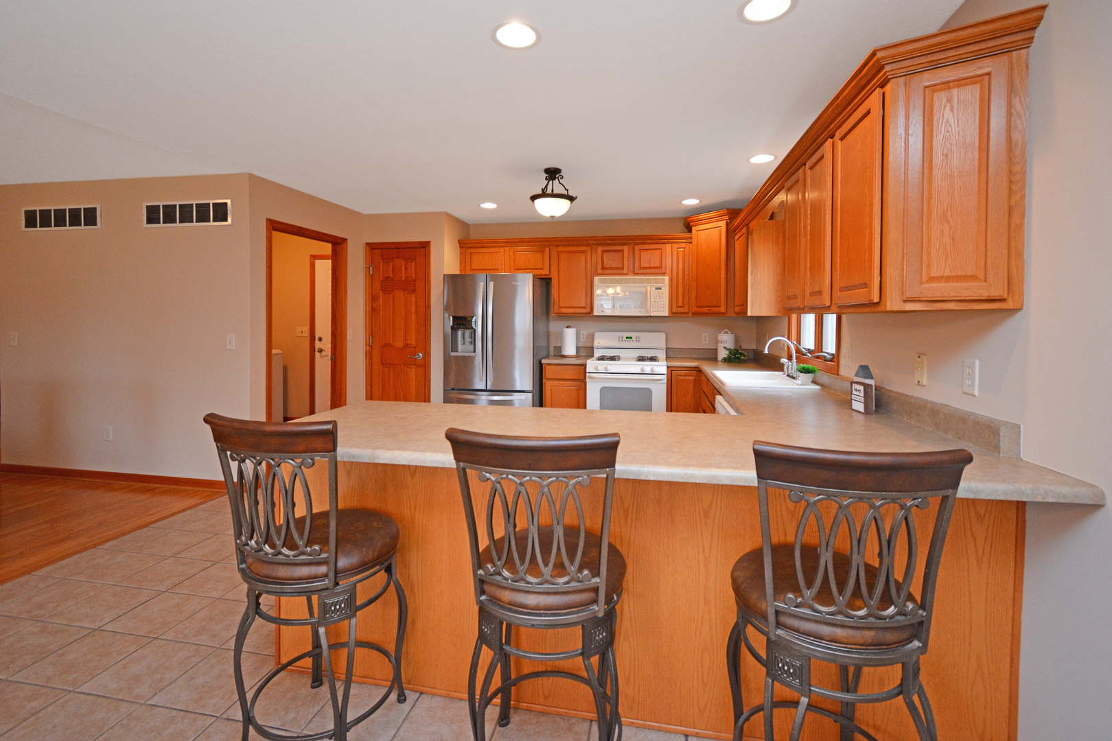 2884 Bear Claw Street Normal, IL 61761 - Photo 19 of 62 a kitchen with stainless steel appliances a dining table chairs and a refrigerator