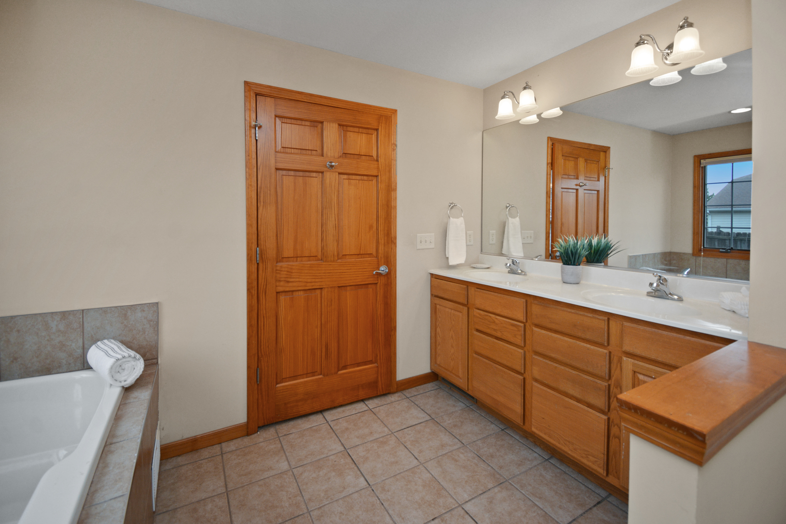 2884 Bear Claw Street Normal, IL 61761 - Photo 39 of 62 a spacious bathroom with a double vanity sink a mirror and a bathtub