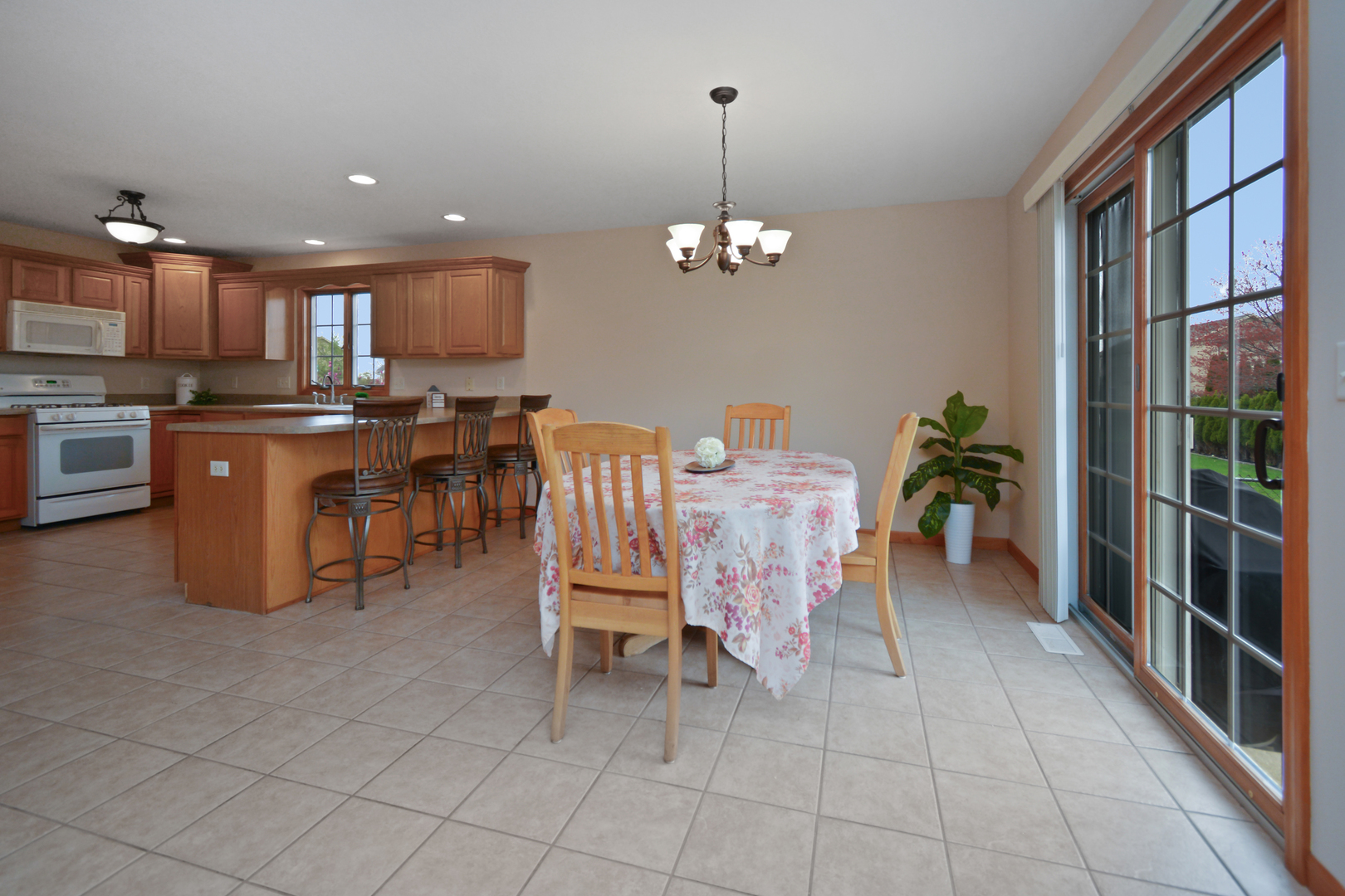 2884 Bear Claw Street Normal, IL 61761 - Photo 57 of 62 a dining room with furniture a chandelier and kitchen view